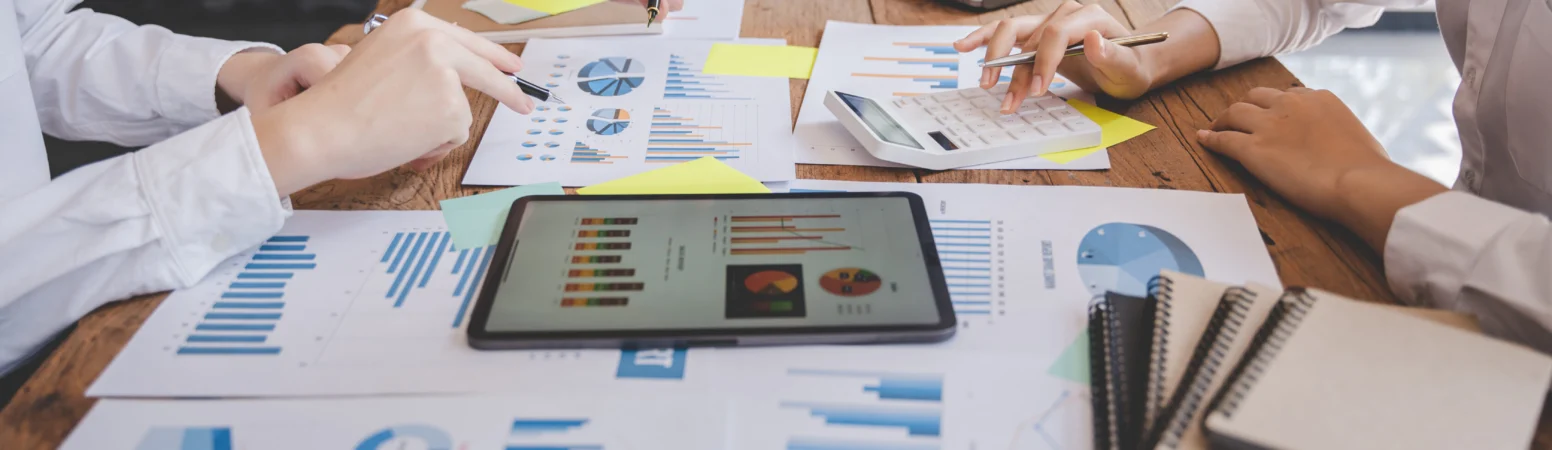 Business team analyzing market data and financial reports on a conference table.