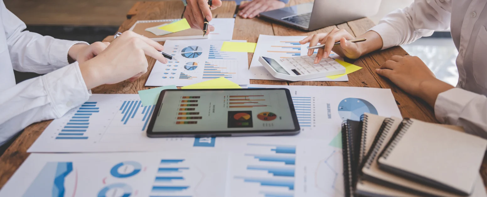 Business team analyzing market data and financial reports on a conference table.